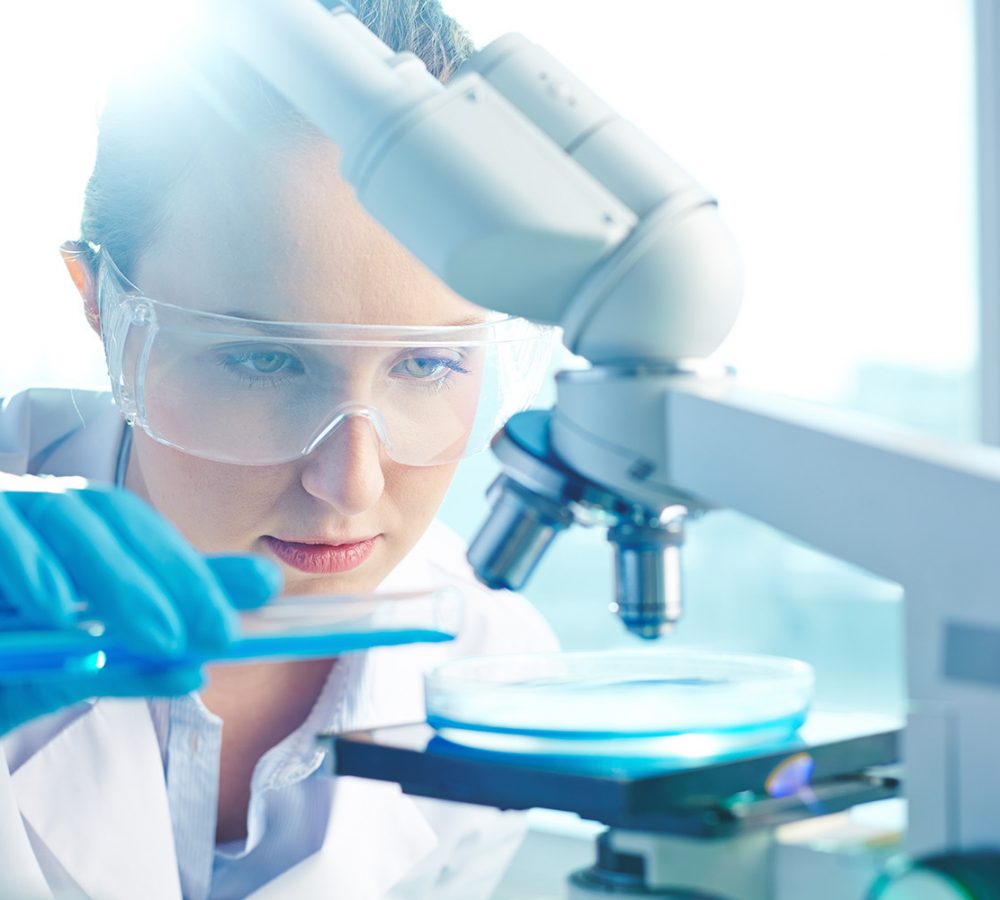 Female researcher using her microscope in a laboratory